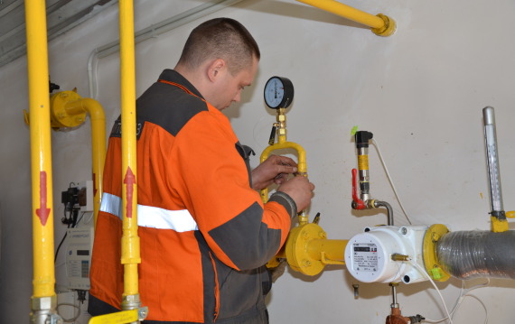Працівник аварійно-диспетчерської служби перевіряє газове обладнання